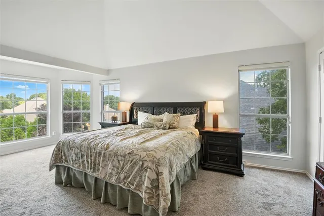 a bedroom with a bed and large windows