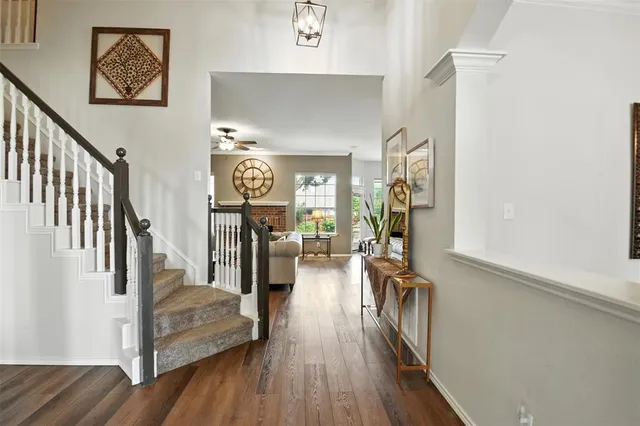 a view of a hallway with wooden floor and stairs