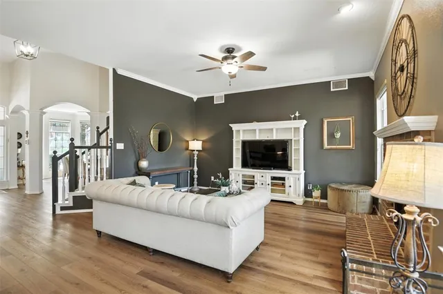 a living room with furniture flat screen tv and wooden floor