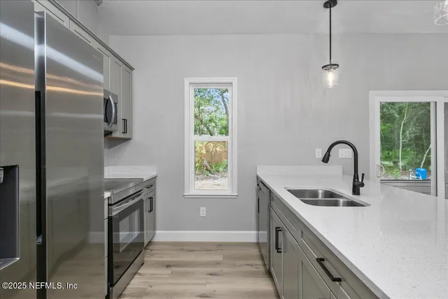 a kitchen with stainless steel appliances granite countertop a sink a stove and a refrigerator