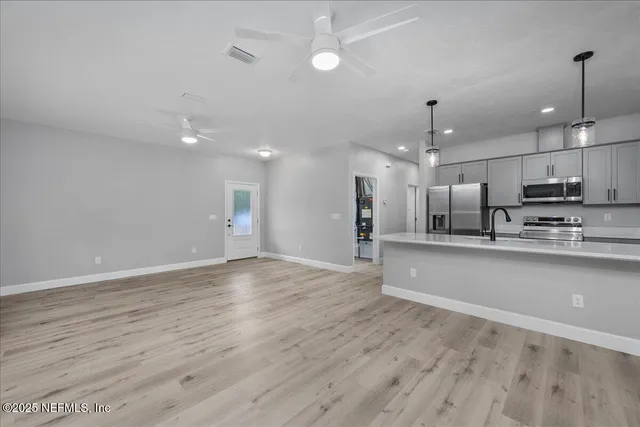wooden floor in an empty room with kitchen view