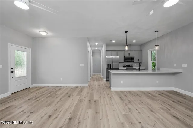 a view of kitchen with refrigerator stove and wooden floor