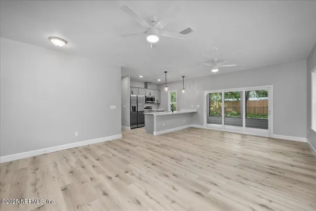 a view of empty room with wooden floor and window