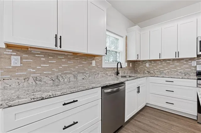 a kitchen with granite countertop white cabinets and white appliances