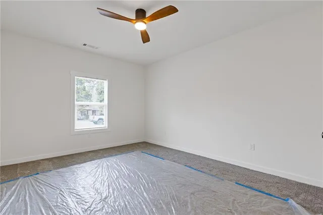 an empty room with a window and ceiling fan
