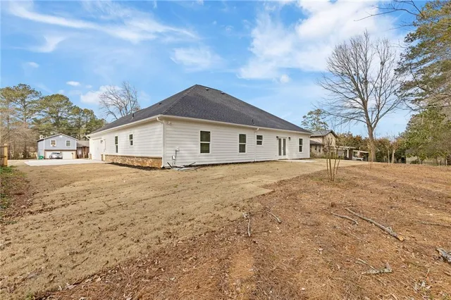 a view of house with yard and car parked