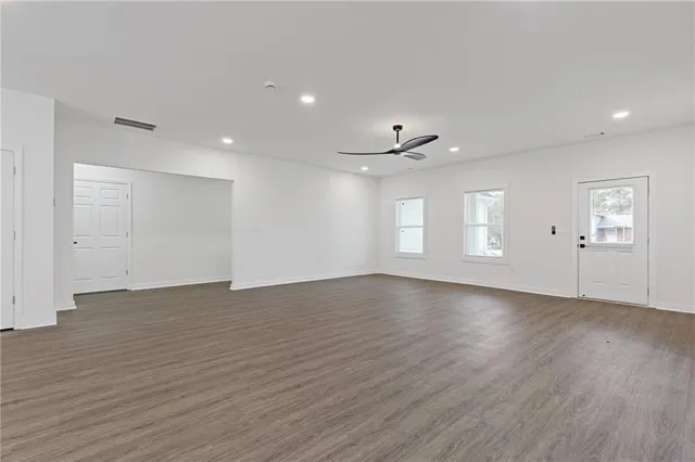 an empty room with wooden floor and window