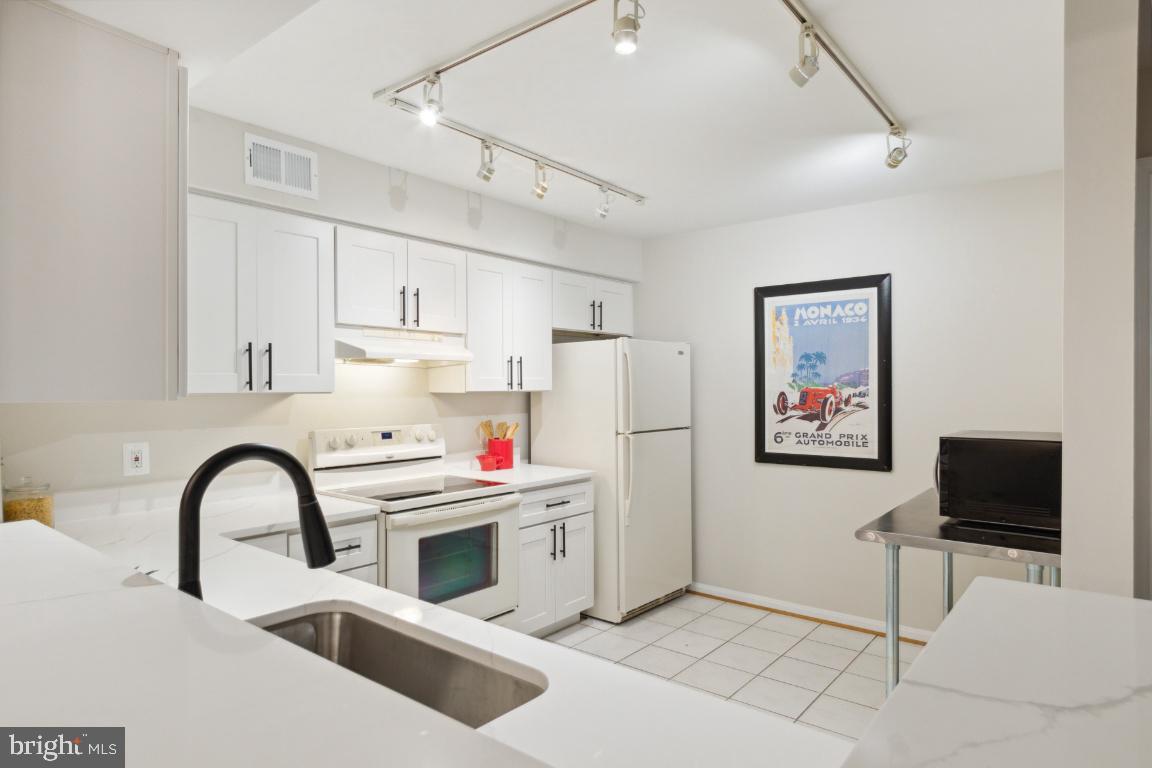 2241 Lovedale Lane, Unit D Reston, VA 20191 - Photo 10 of 31 a kitchen with stainless steel appliances a stove a sink and a refrigerator