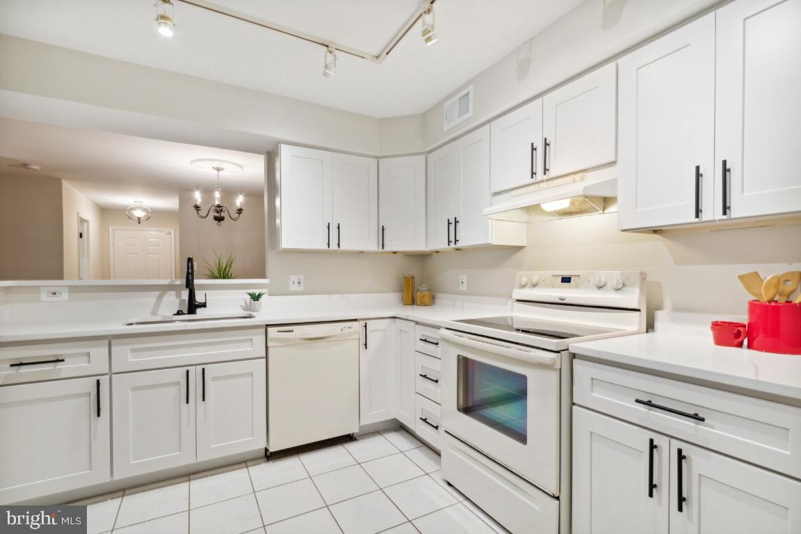 2241 Lovedale Lane, Unit D Reston, VA 20191 - Photo 12 of 31 a kitchen with white cabinets stainless steel appliances and sink