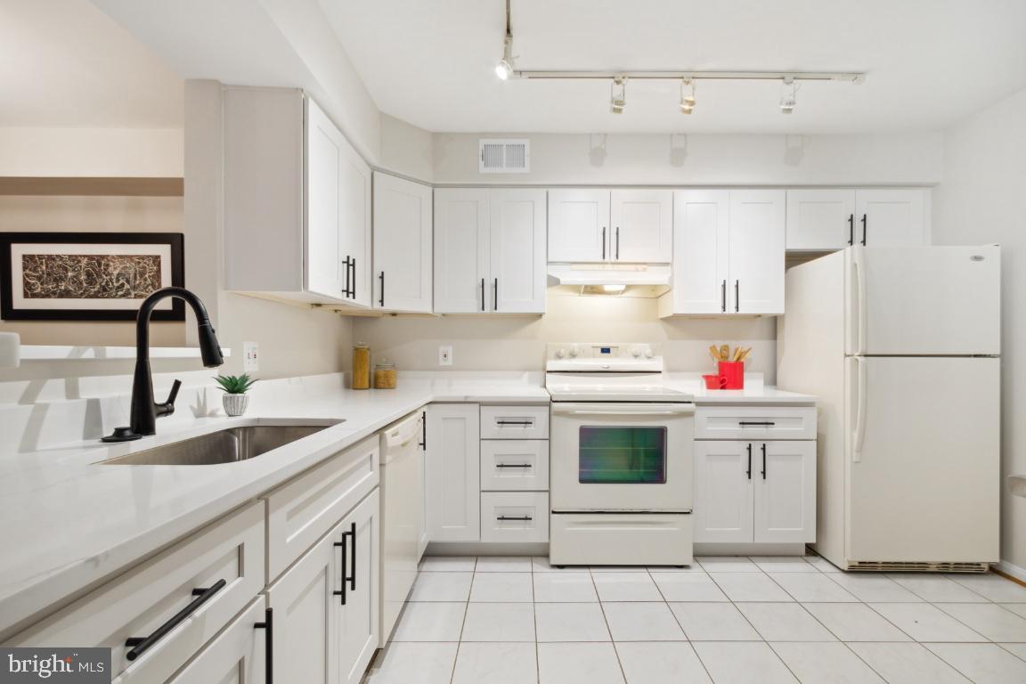 2241 Lovedale Lane, Unit D Reston, VA 20191 - Photo 9 of 31 a kitchen with white cabinets a sink and white appliances