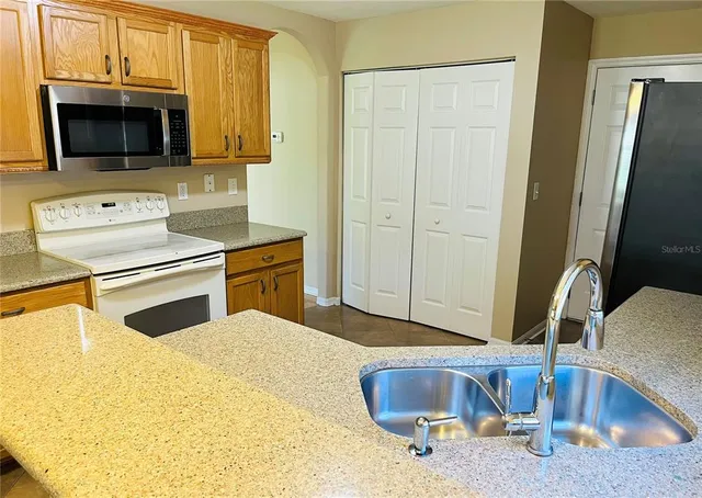 a view of a kitchen with refrigerator and wooden floor