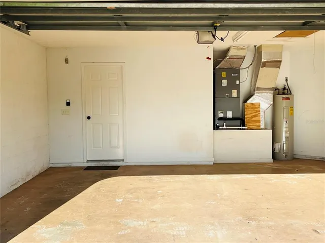 a view of a house with a yard potted plants and a table