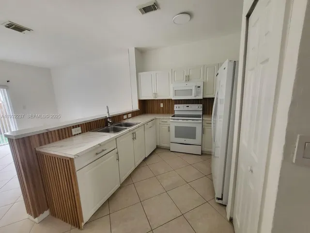 a kitchen with a sink stove and cabinets