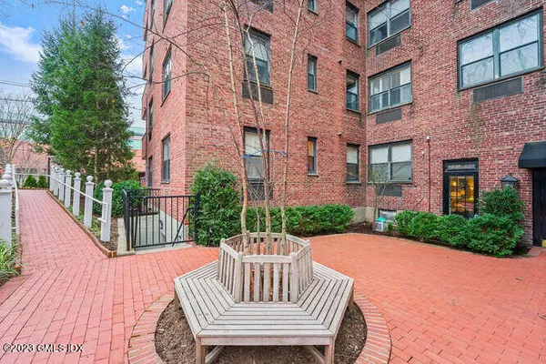 a view of a patio with couches table and chairs and wooden fence