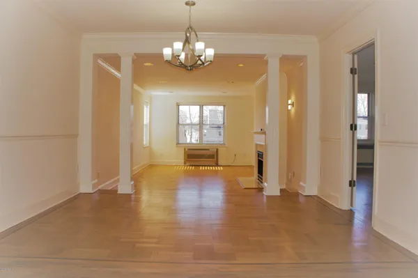a view of a big room with wooden floor and windows