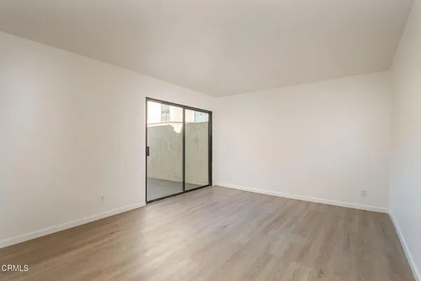 an empty room with wooden floor and mirror