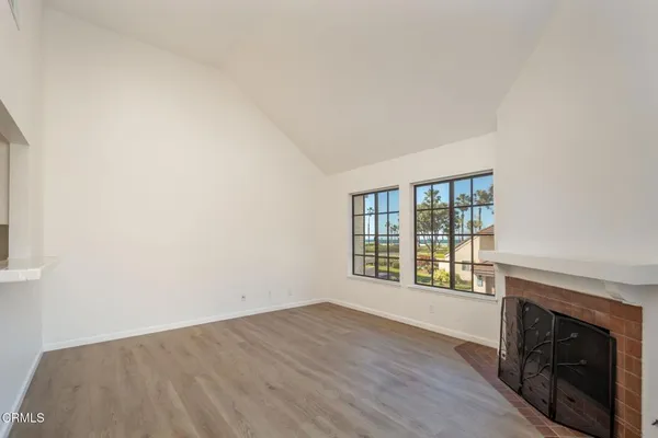 a view of an empty room with a fireplace and a window