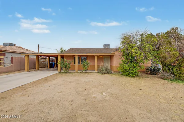 front view of a house with a yard and potted plants