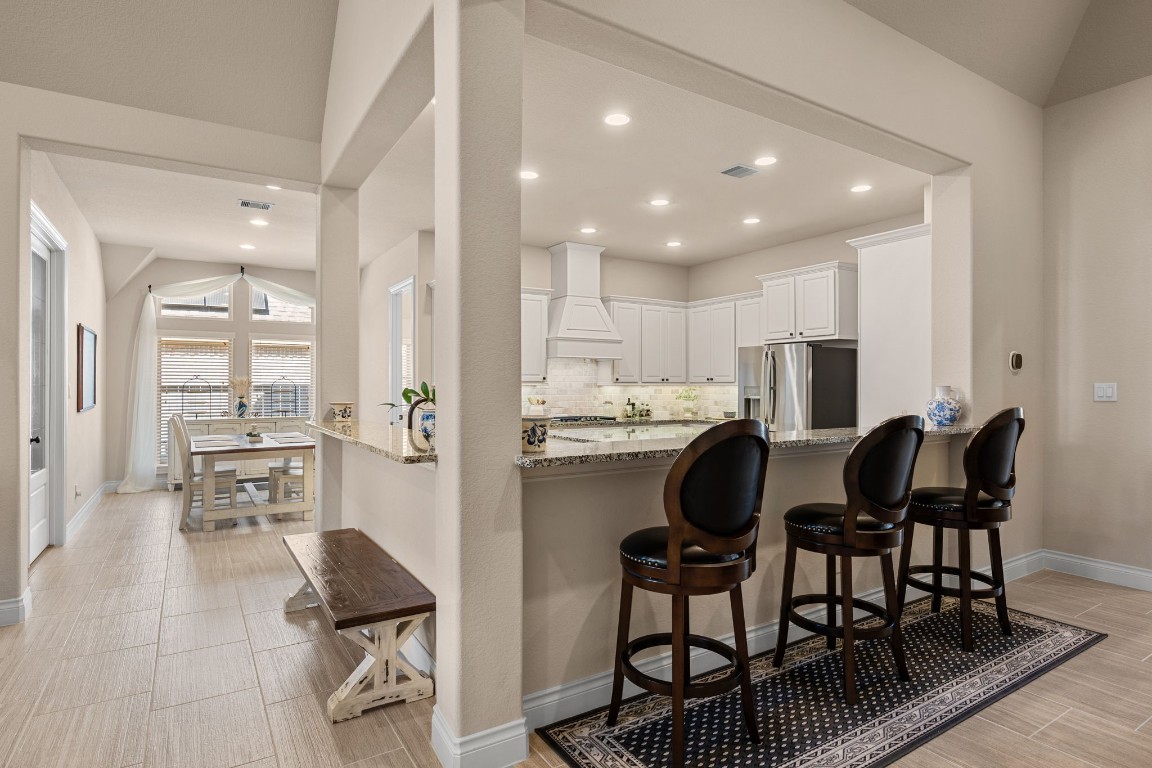 1607 Dove Ridge Drive Katy, TX 77493 - Photo 11 of 38 a kitchen with stainless steel appliances kitchen island granite countertop a dining table chairs and view of living room