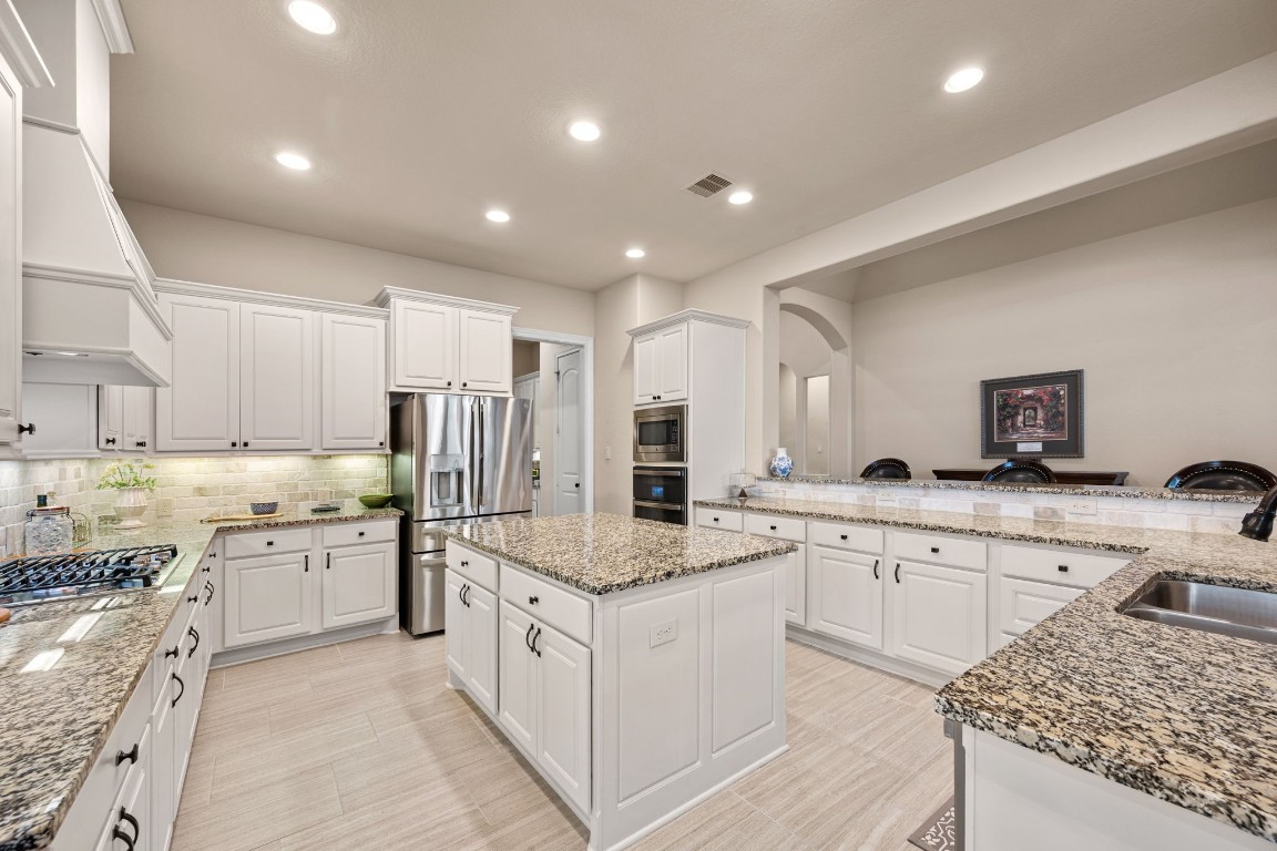 1607 Dove Ridge Drive Katy, TX 77493 - Photo 12 of 38 a kitchen with granite countertop sink and stainless steel appliances