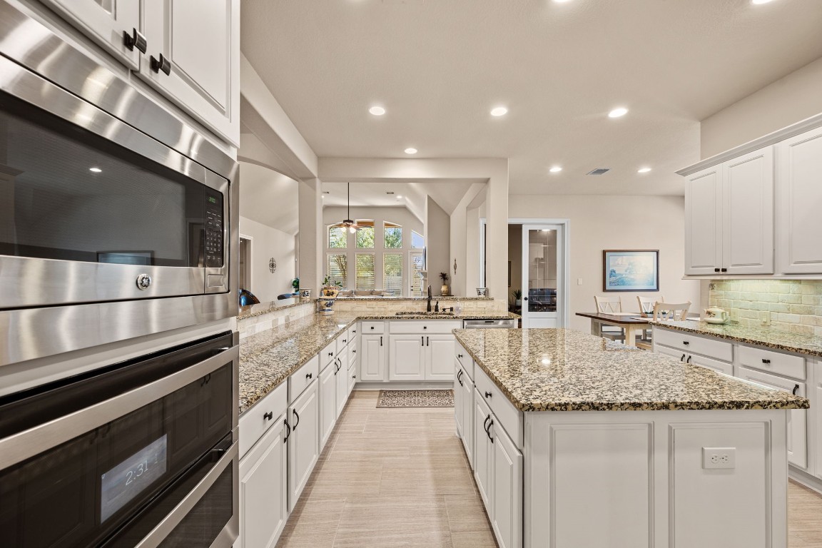 1607 Dove Ridge Drive Katy, TX 77493 - Photo 14 of 38 a large kitchen with granite countertop a stove and a sink