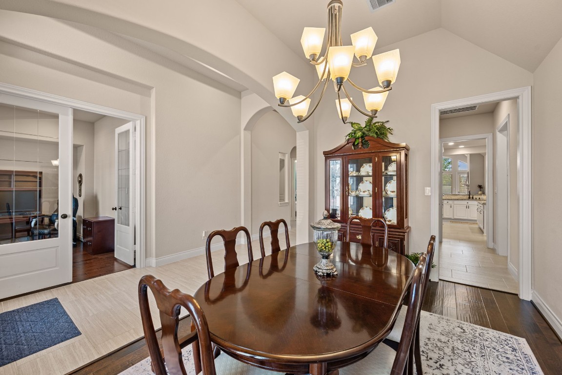 1607 Dove Ridge Drive Katy, TX 77493 - Photo 19 of 38 a dining room with wooden floor a chandelier a wooden table and chairs