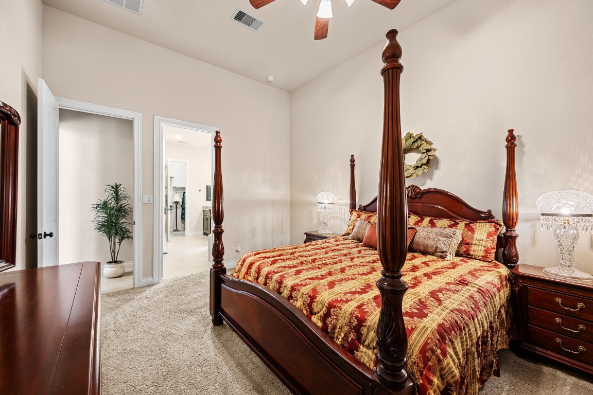 1607 Dove Ridge Drive Katy, TX 77493 - Photo 24 of 38 a bedroom with a large bed and a chandelier