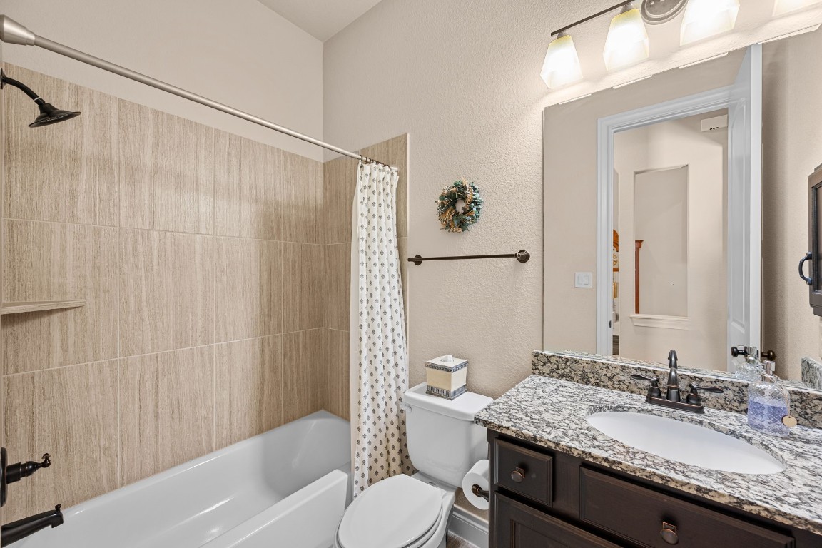 1607 Dove Ridge Drive Katy, TX 77493 - Photo 30 of 38 a bathroom with a granite countertop sink toilet and shower