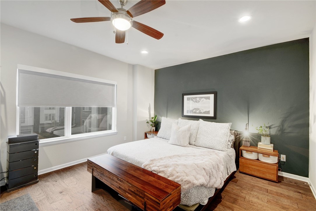 4405 Swift Path, Unit 17 Austin, TX 78741 - Photo 12 of 33 a bedroom with a large bed and a chandelier