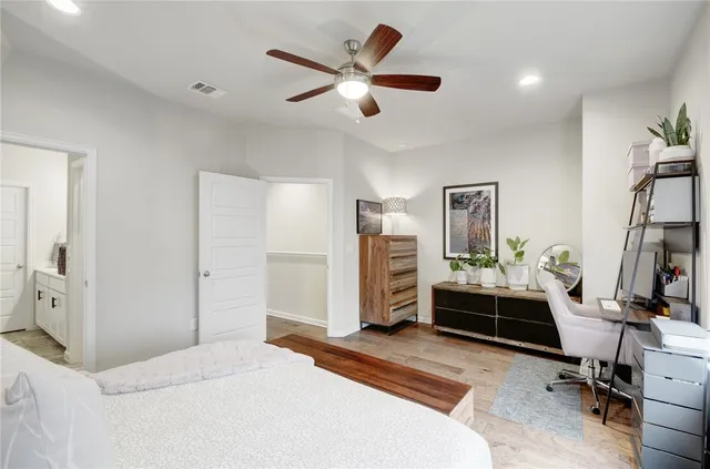 a bedroom with a large bed and a chandelier