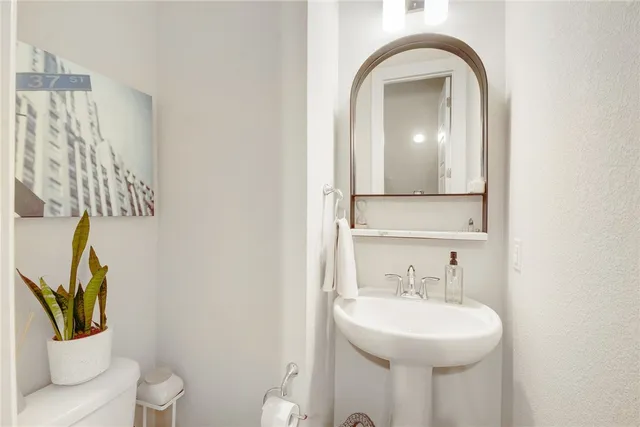 a bathroom with a toilet sink and mirror