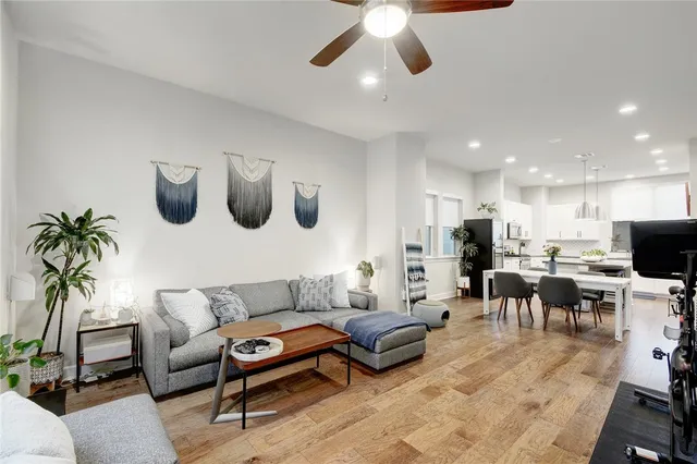 a living room with furniture kitchen view and a potted plant
