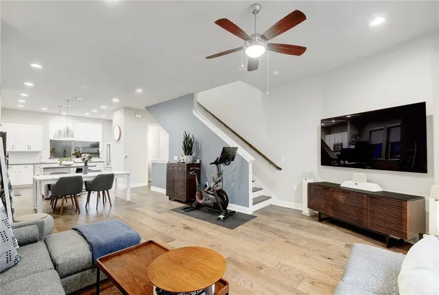 a living room with furniture kitchen view and a flat screen tv