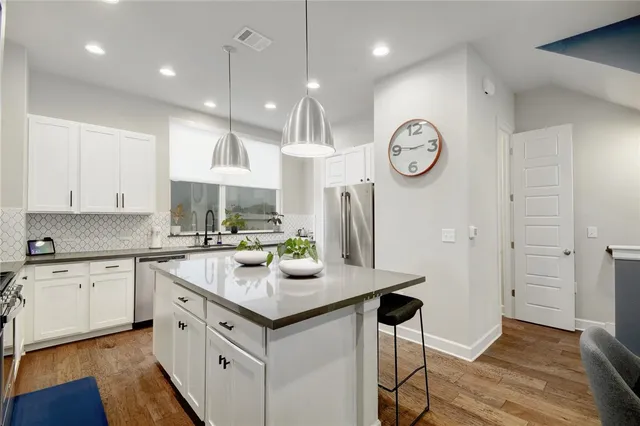 a kitchen with a refrigerator a sink and cabinets