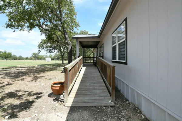 a kitchen with stainless steel appliances a stove a sink dishwasher a refrigerator white cabinets and wooden floor