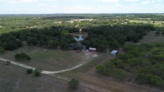 an aerial view of green landscape with trees houses and lake view