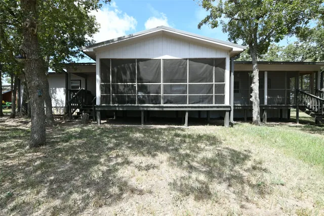 a kitchen with stainless steel appliances a stove a sink dishwasher a refrigerator white cabinets and wooden floor