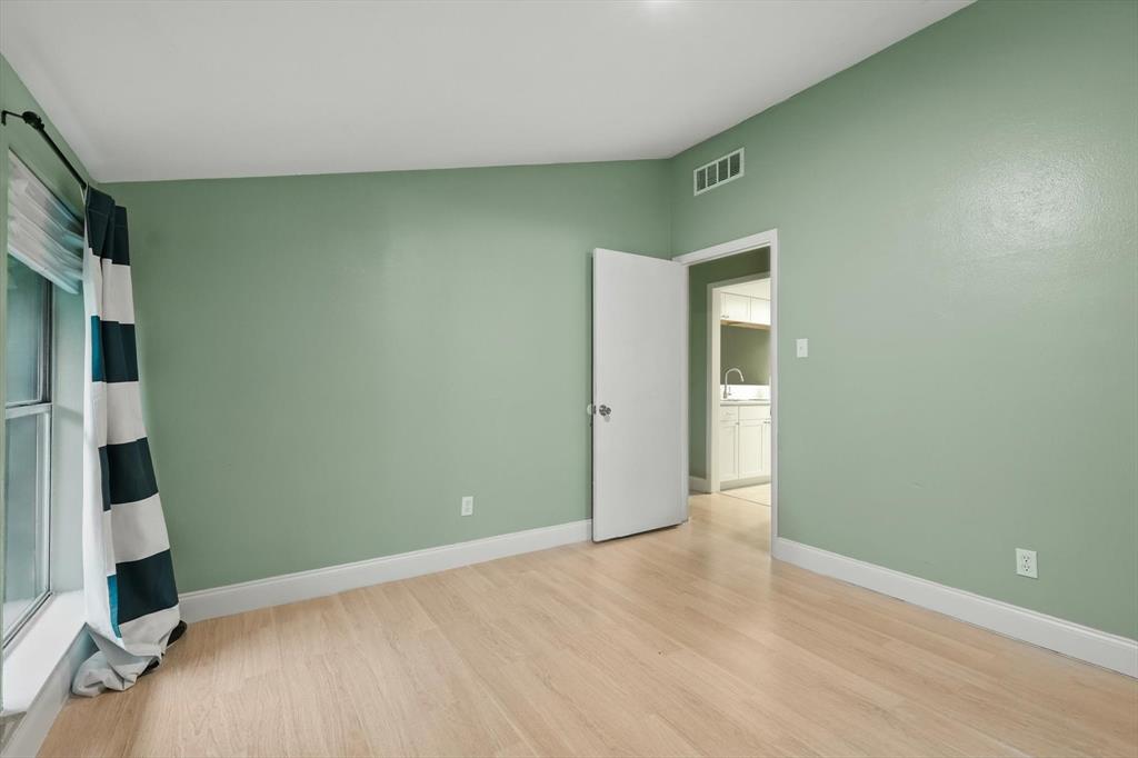 12824 Midway Road, Unit 2136 Dallas, TX 75244 - Photo 22 of 40 a view of an empty room with wooden floor and a window