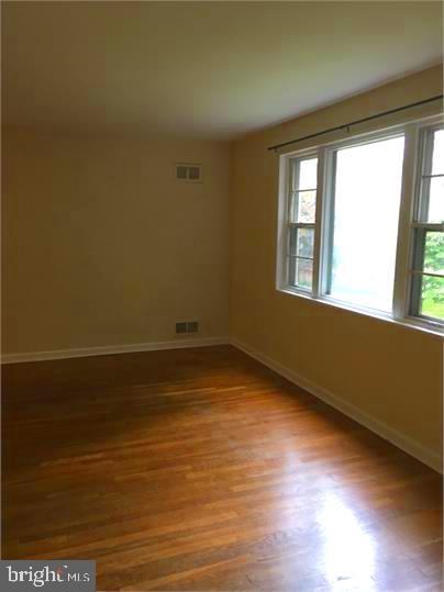 5319 Pooks Hill Road, Unit 1 Bethesda, MD 20814 - Photo 11 of 18 a view of an empty room with wooden floor and a window