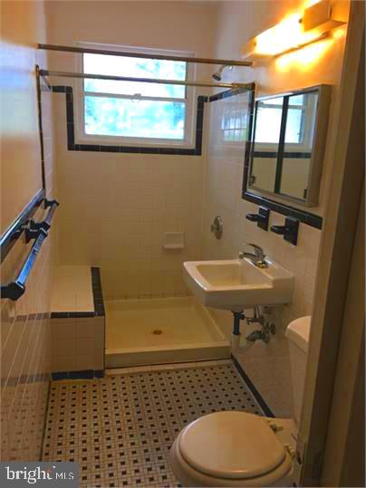 5319 Pooks Hill Road, Unit 1 Bethesda, MD 20814 - Photo 14 of 18 a bathroom with a sink a toilet a mirror and shower