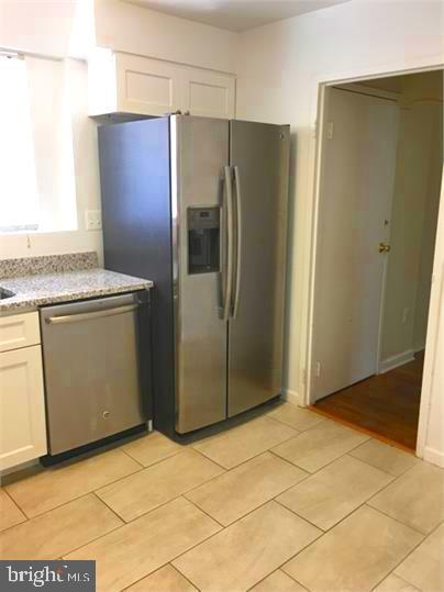 5319 Pooks Hill Road, Unit 1 Bethesda, MD 20814 - Photo 5 of 18 a view of a refrigerator in kitchen and an empty room
