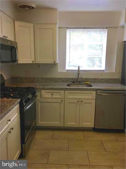5319 Pooks Hill Road, Unit 1 Bethesda, MD 20814 - Photo 6 of 18 a kitchen with granite countertop a sink stove and cabinets