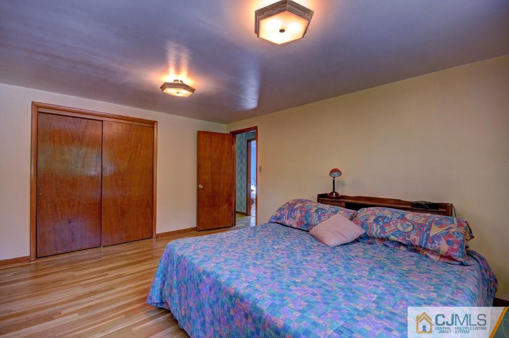 5 Timber Road East Brunswick, NJ 08816 - Photo 10 of 25 a bedroom with a bed and a lamp on dresser