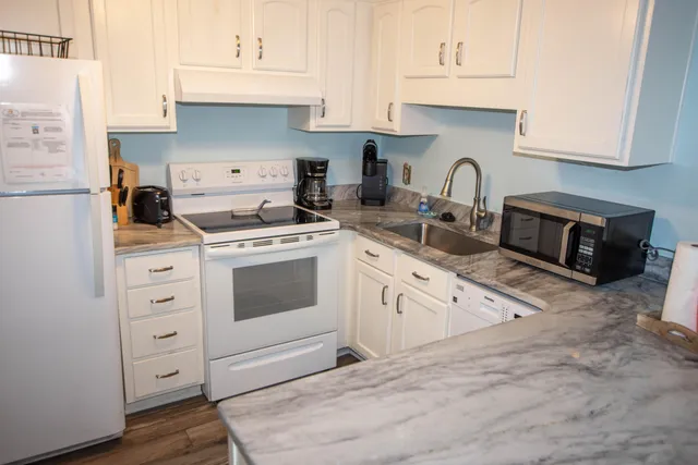 a kitchen with cabinets appliances and a wooden floor