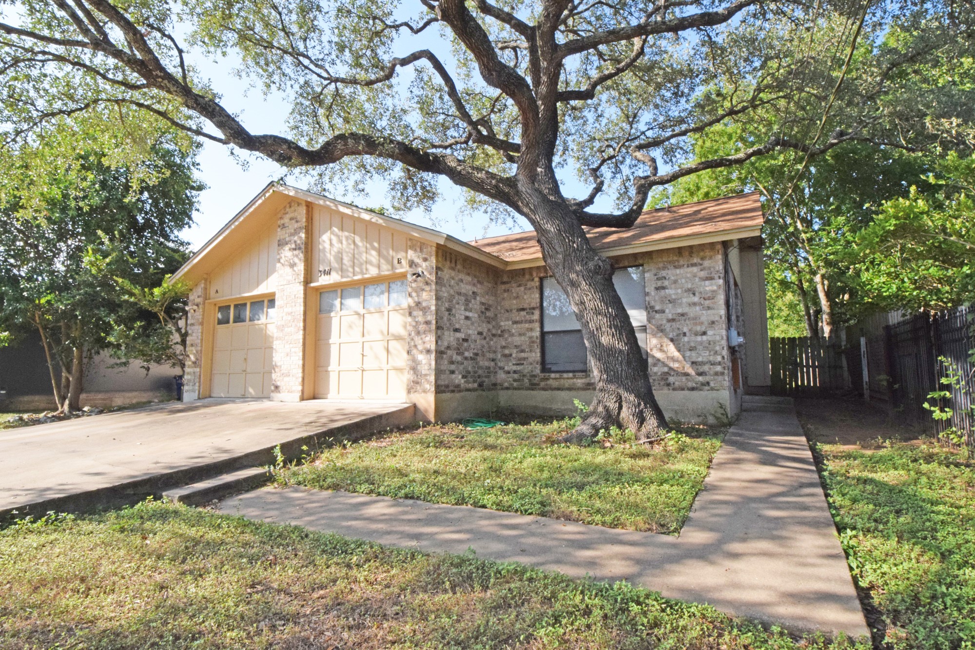 a front view of a house with a yard and an trees