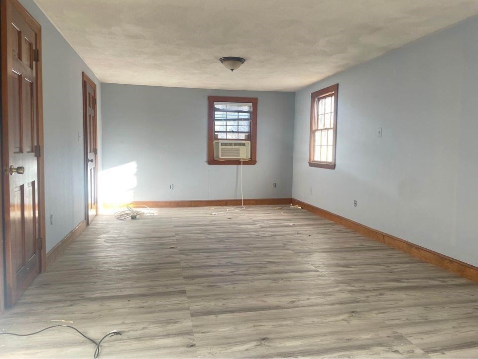 49 Baxter Street Medford, MA 02155 - Photo 2 of 6 a view of empty room with wooden floor and fan