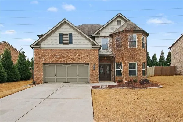 a front view of a house with yard and trees