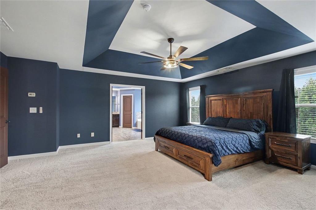 3499 In Bloom Way Auburn, GA 30011 - Photo 15 of 30 a spacious bedroom with a large bed and a chandelier