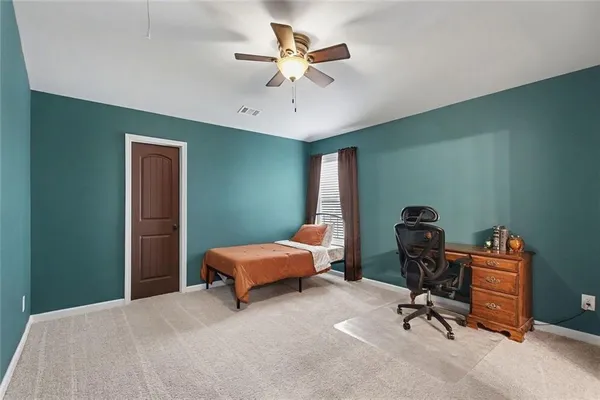 a bedroom that has a bed and a chair in it