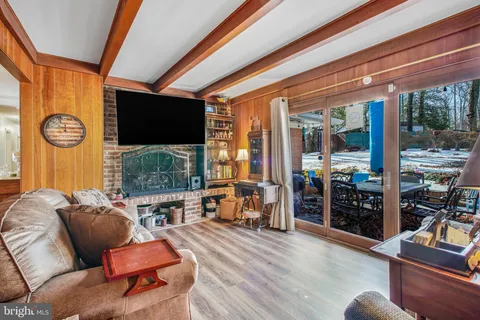 a living room with furniture a flat screen tv and a floor to ceiling window